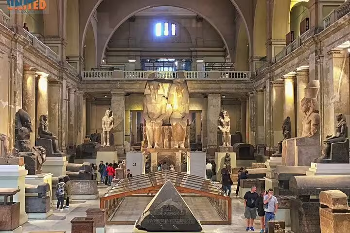 Visitors exploring Egyptian Museum Cairo main gallery and pharaoh statues on Pyramids of Giza private tour