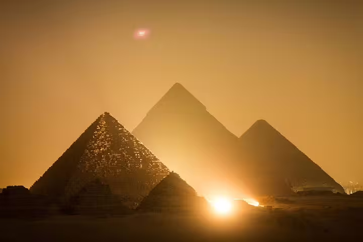 Sunset view of the Pyramids of Giza in Cairo, a highlight of the pyramids tour with museum visit and dinner cruise