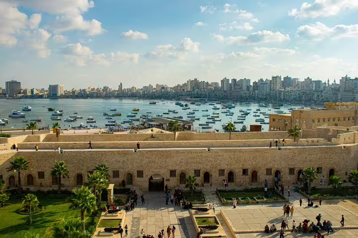 View of Alexandria Citadel and harbor boats from Qaitbay Fort, highlight of private tour from Cairo