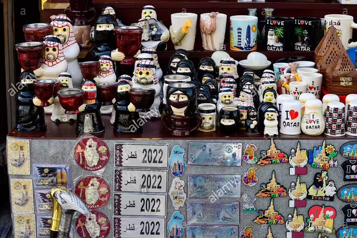 Colorful Qatar souvenirs including mugs and figurines at Souq Waqif, ideal for cultural shopping in Doha.