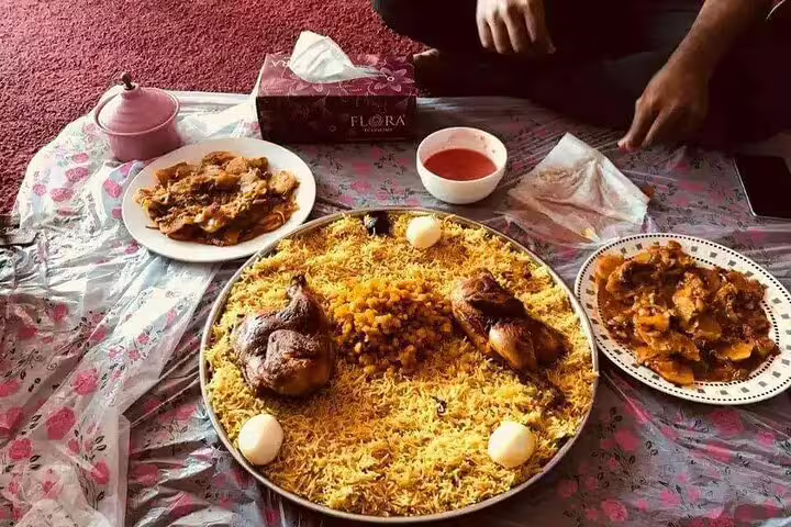 Traditional Qatari meal featuring spiced rice, roasted chicken, and sides, highlighting Doha's authentic culinary experience.