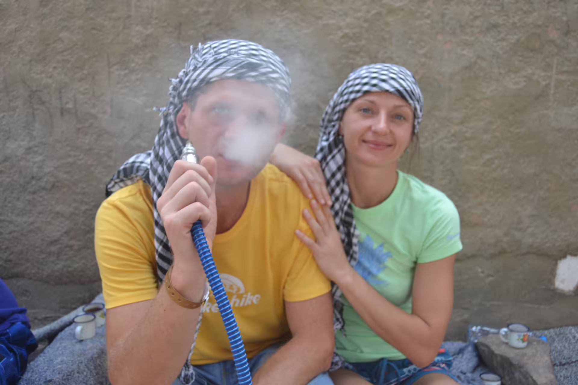 Tourists in Bedouin scarves enjoying shisha during a Quad Tour Hurghada desert safari village stop