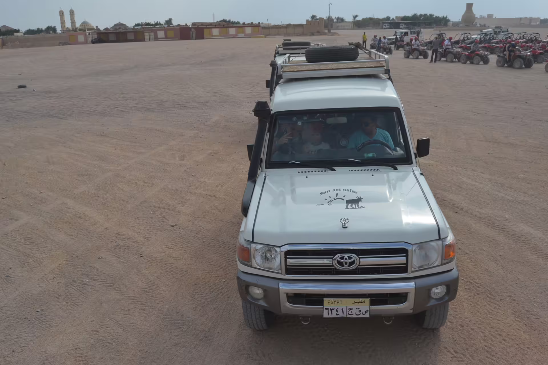 4x4 Toyota Land Cruiser support vehicle at Hurghada quad bike safari base with ATVs lined up in desert