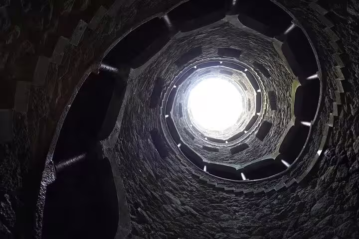 View from inside the Initiation Well at Quinta da Regaleira in Sintra, showcasing its enchanting spiral staircase and mystical architecture.