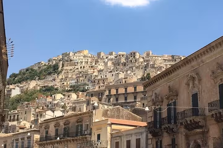 Hilltop view of Ragusa Ibla's stunning Baroque architecture under a clear blue sky, perfect for exploring historic sites.