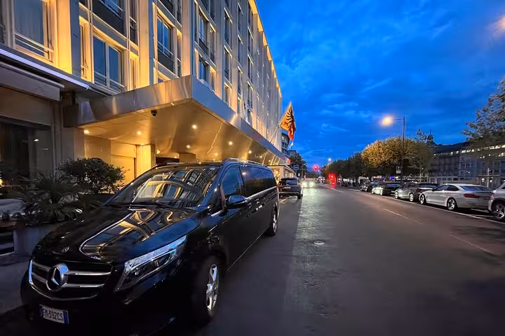 Sleek black Mercedes parked at illuminated hotel entrance, ideal for Ravenna to Bologna airport transfers.