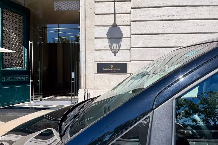 Close-up of sleek black van at hotel entrance, part of premium transfer service from Ravenna Cruise Terminal to Bologna Airport.