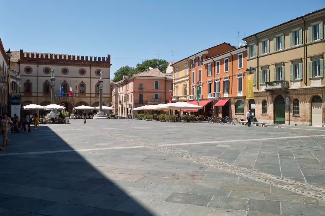 Sunny Piazza del Popolo in Ravenna with historic palaces, colorful facades and café terraces on a private walking tour