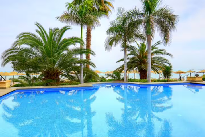 Red Sea resort infinity pool with palm trees, relaxing beach escape on a 4-day Cairo and Red Sea package