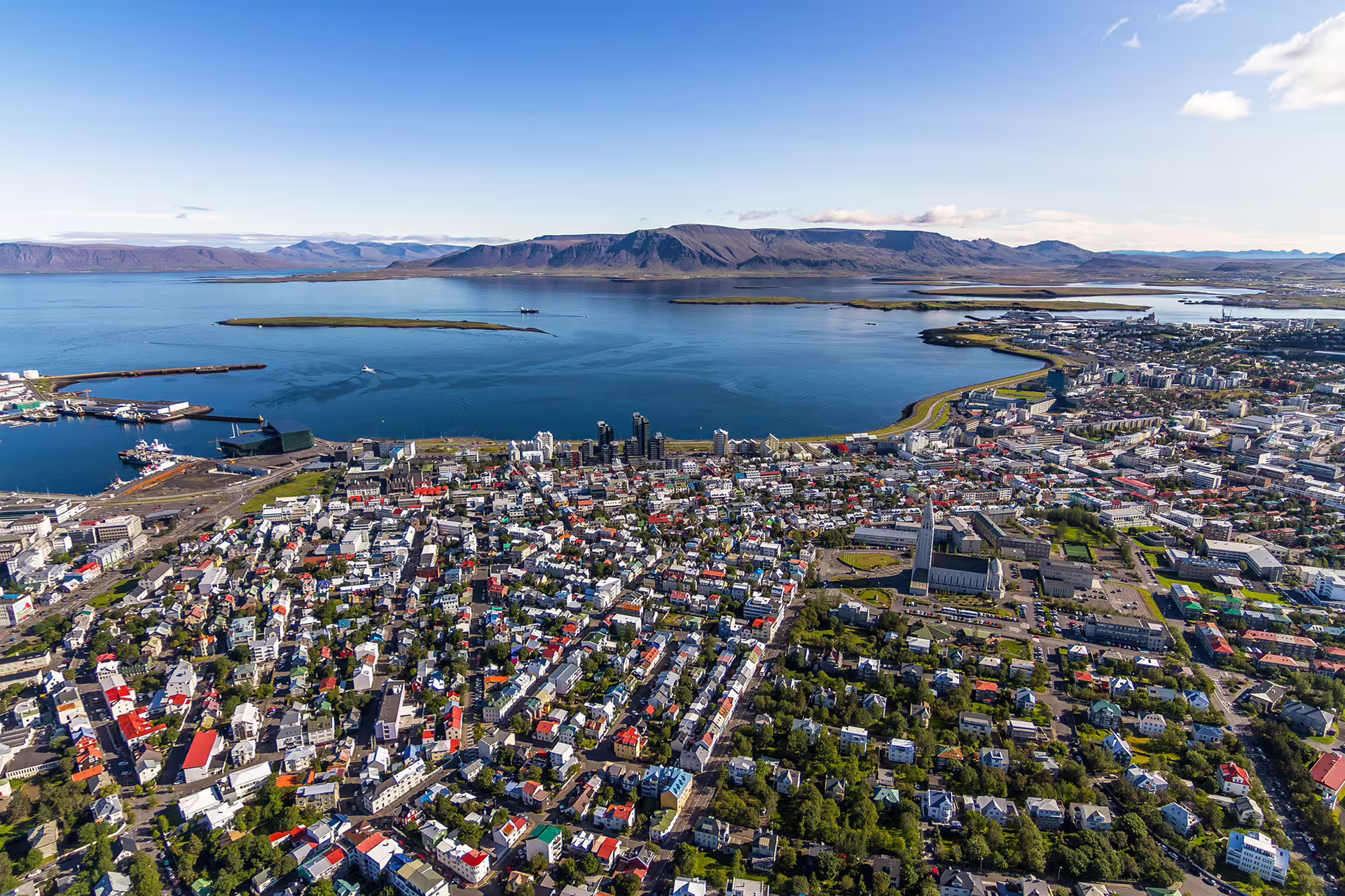 Aerial view of Reykjavik cityscape, vibrant buildings, and scenic coastline, ideal for ATV and helicopter adventure tours.