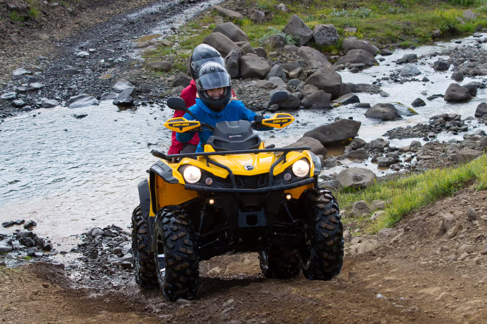 Adventurers enjoy an exhilarating ATV ride through rugged terrain and streams in Reykjavik's scenic landscapes.
