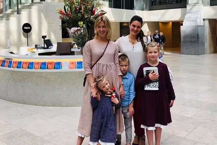 Visitors at Rijksmuseum entrance hall before a guided masterpieces tour, tickets desk and museum lobby