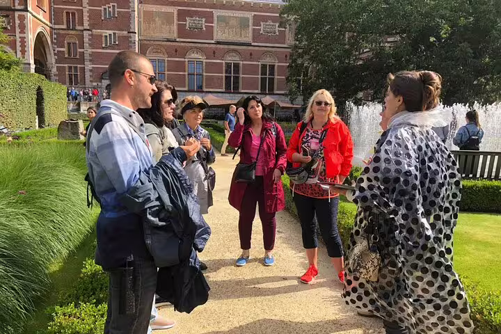 Small group outside the Rijksmuseum with guide, starting “Stories Behind the Masterpieces” walking tour