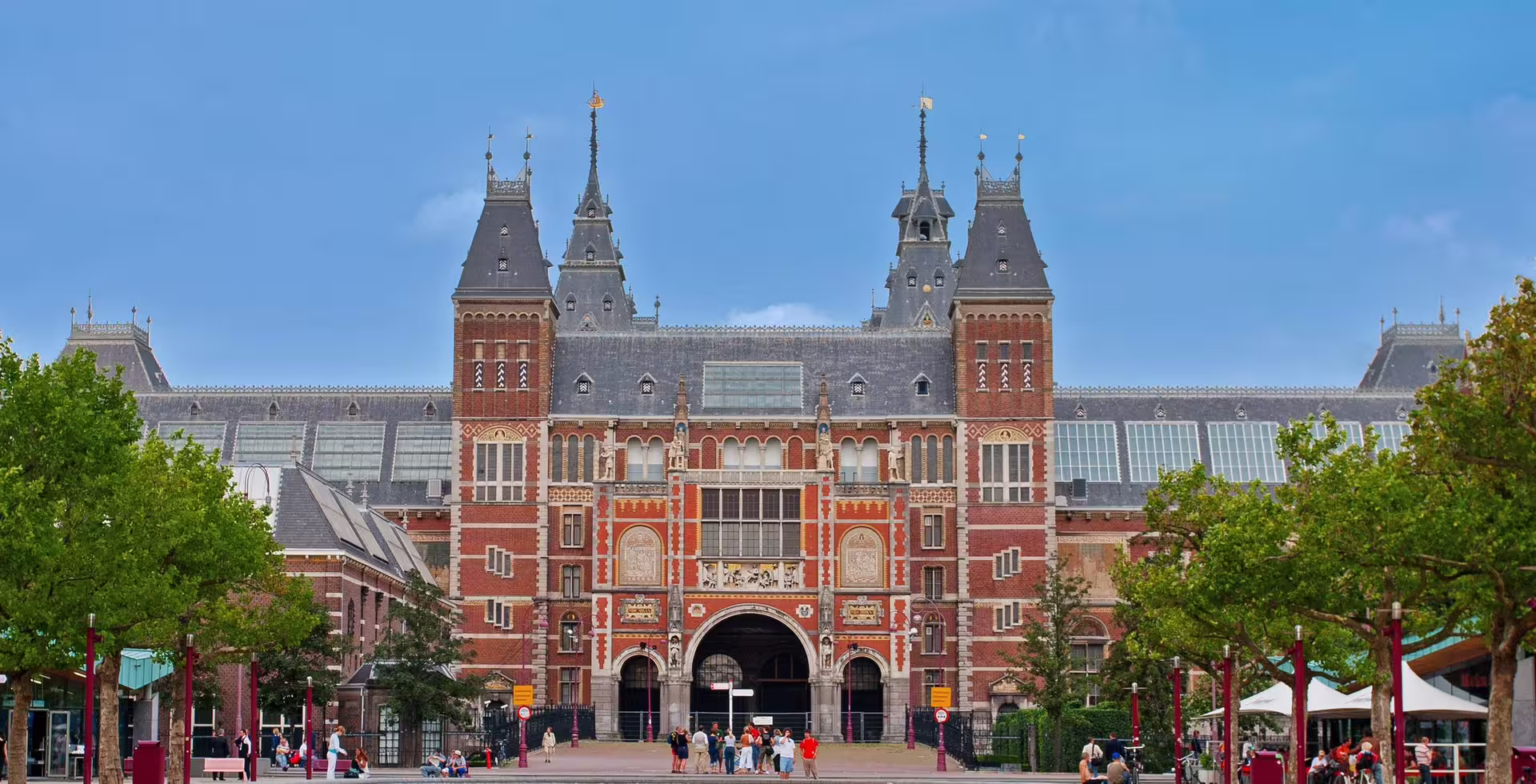 Visitors gather outside the grand entrance of the Rijksmuseum in Amsterdam, ready for a private guided tour of its art collections.