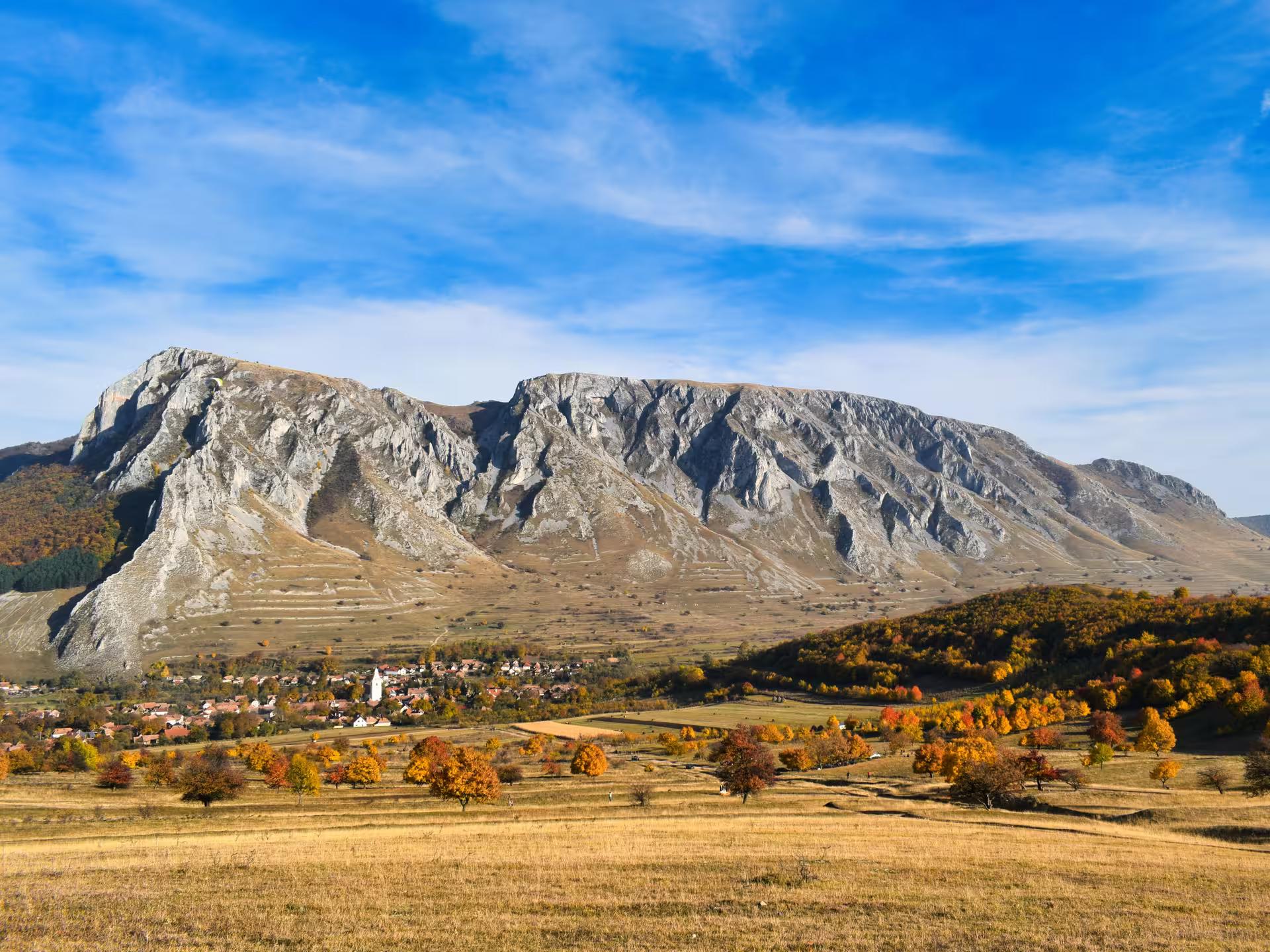 Stunning autumn landscape of Rimetea village with rocky Transylvanian mountains on a scenic full-day tour Romania
