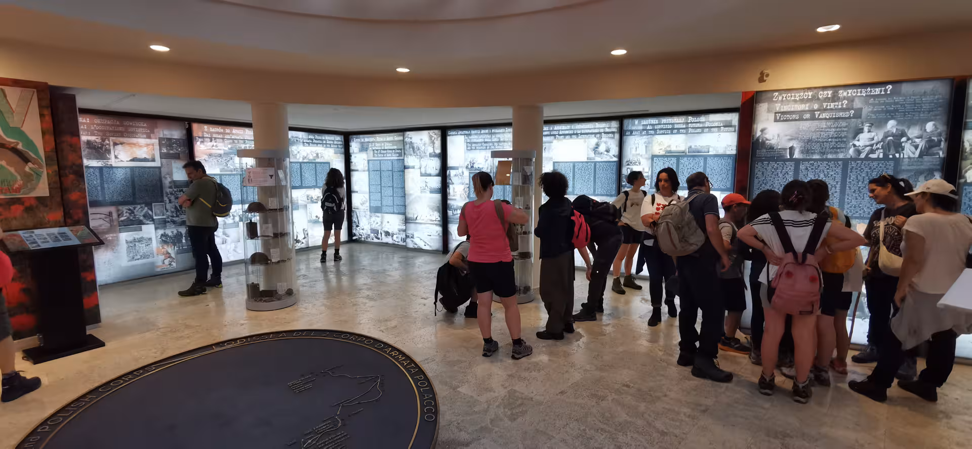 Tourists engage with informative displays at L'Anello della Collina Imprendibile, showcasing historical artifacts and stories.