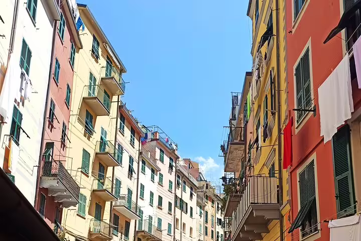 Narrow street lined with vibrant pastel buildings and balconies in Riomaggiore on a Cinque Terre private walking tour