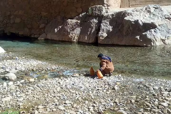 Local washing by a clear river gorge, scenic stop on 3-day private desert tour Marrakech to Fes