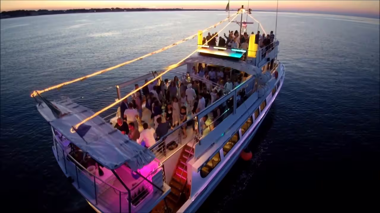 Sunset party cruise on a Riviera Romagnola boat tour, lively deck lights and Adriatic Sea views