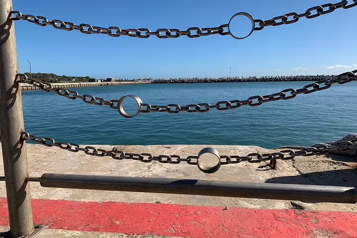 View of Robben Island harbor with chains and clear blue water, highlighting the starting point of the guided tour.