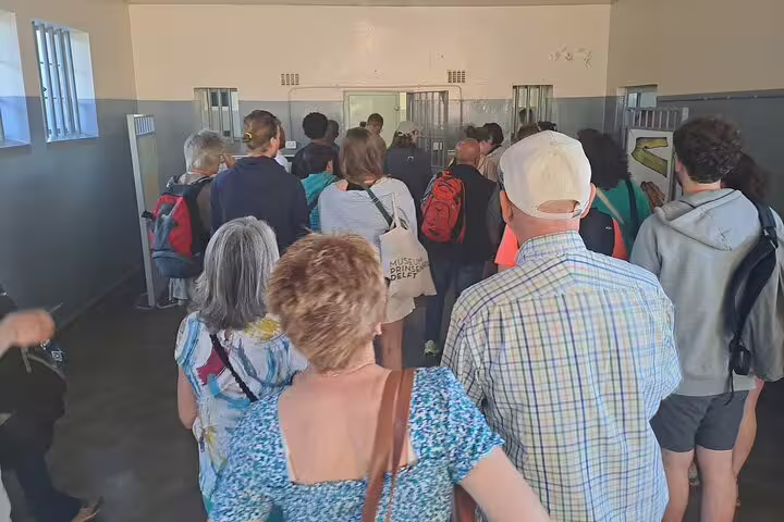 Tour group exploring the interior of Robben Island Museum, engaging with the rich history and cultural significance.