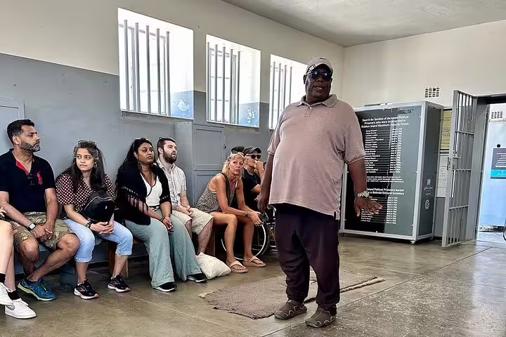 Guide engaging tourists during the Robben Island museum tour, highlighting rich historical insights.