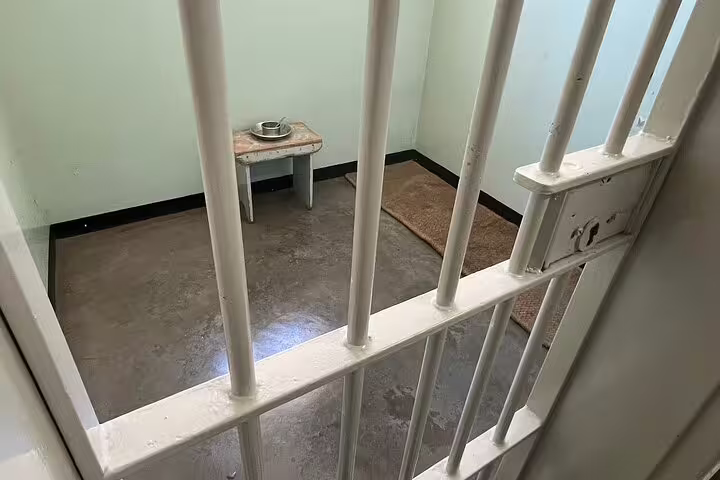 View of a historic prison cell at Robben Island Museum, showcasing the stark conditions of former inmates.