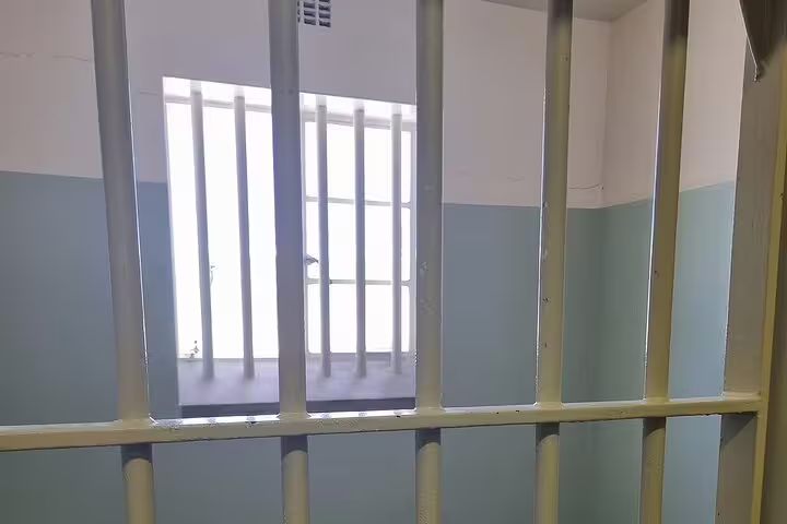 View of a prison cell window with bars at Robben Island, showcasing its historical significance on the tour.