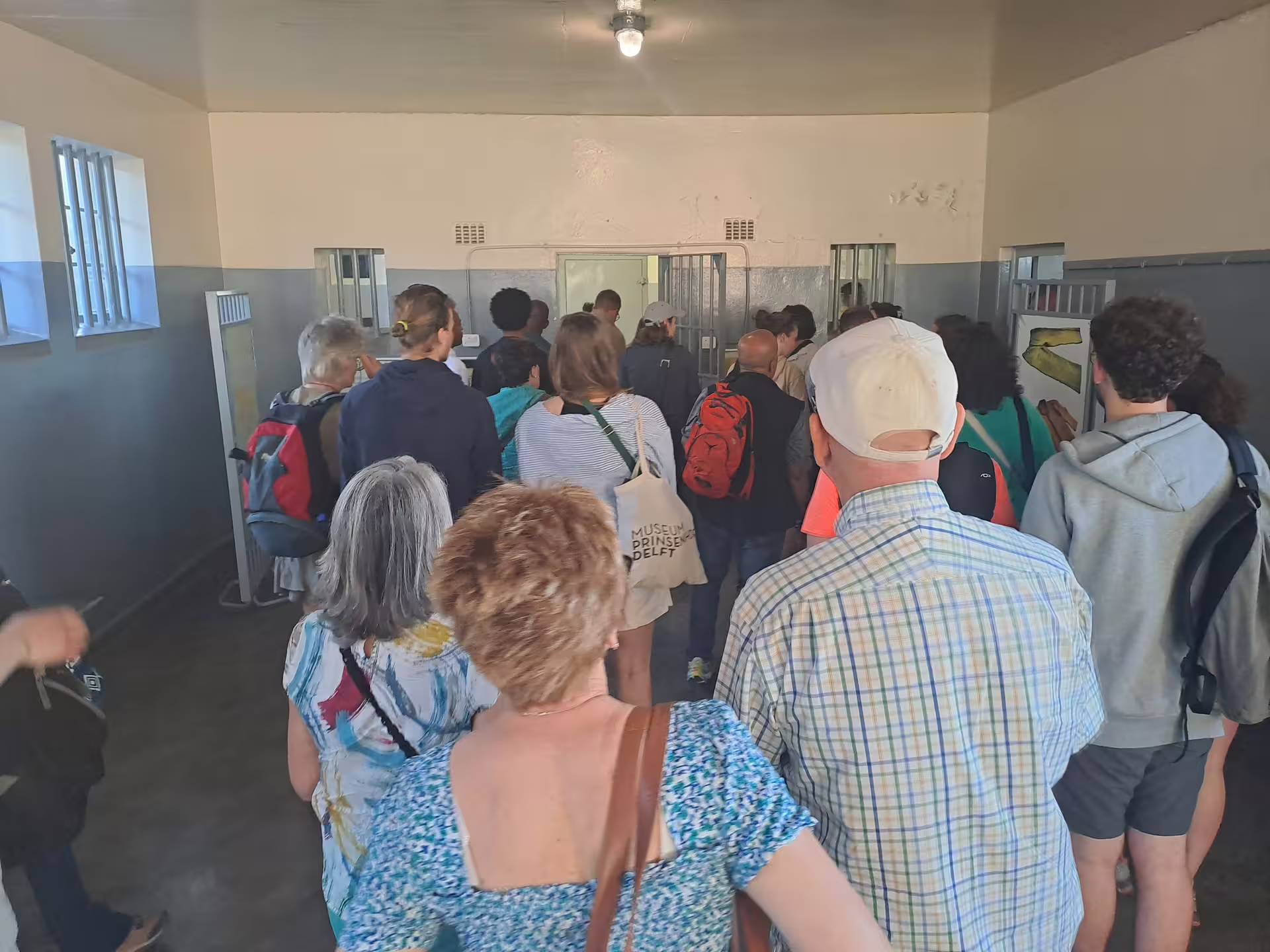 Tourists explore the historic prison cells at Robben Island Museum, a key stop on the ferry tour.