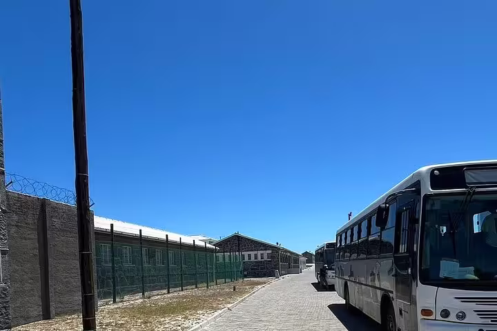 Tour buses parked on Robben Island, ready to transport visitors on the guided museum and ferry experience.