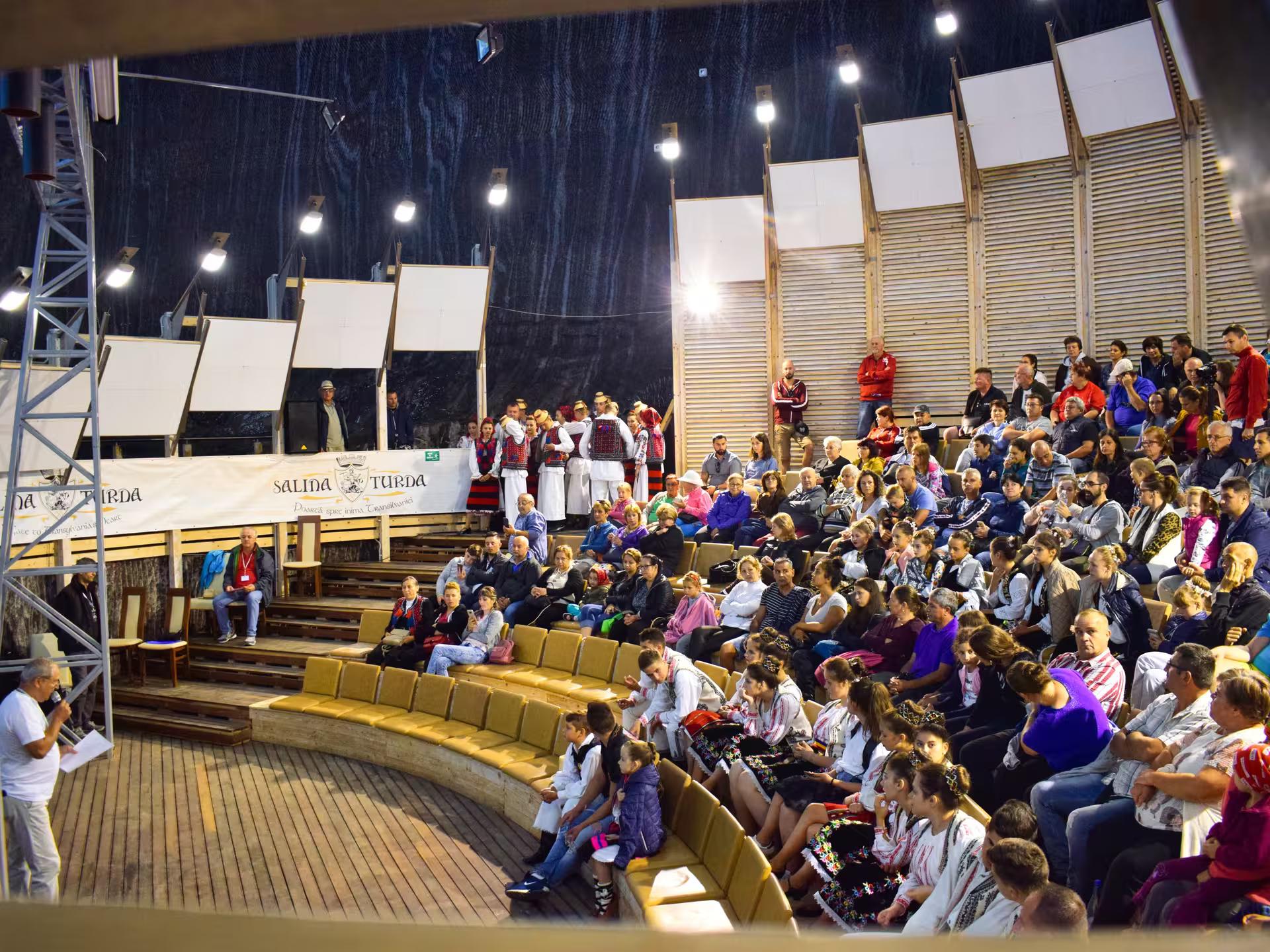 Traditional Romanian folk dance performance inside Salina Turda underground amphitheater during a cultural full-day tour