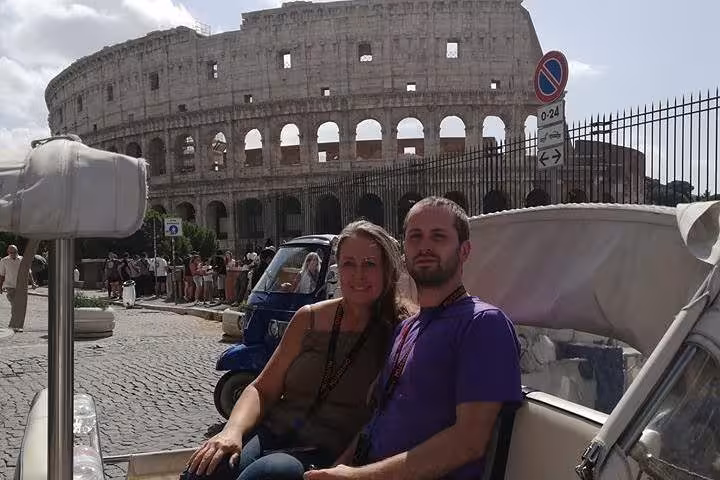 Romantic buggy tour in Rome with a couple seated near the iconic Colosseum, capturing the essence of Italian adventure.