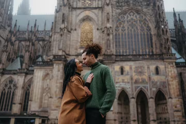 Romantic couple posing in front of the iconic St. Vitus Cathedral in Prague for a professional photoshoot experience.