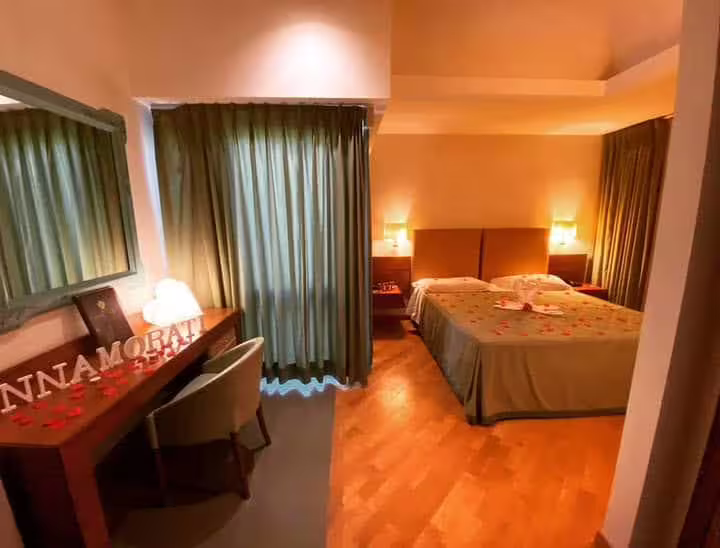 Romantic Solofra hotel room with double bed, rose petals and soft lighting, ideal for a pampering couples escape