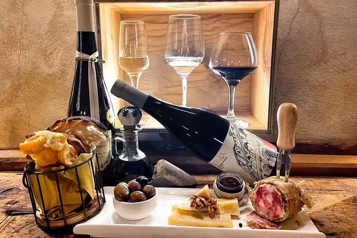 Italian antipasti platter with artisan salami, olives, cheese, bread and premium wine glasses for Rome food and wine pairing tour