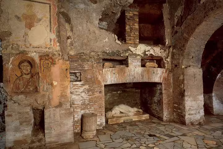 Ancient Roman underground chamber with brick arches, early Christian frescoes and marble tomb on kids friendly Rome catacombs tour