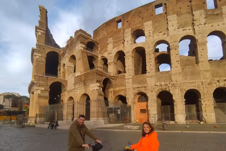 Visitors on e-bikes admire the grandeur of Rome's iconic Colosseum during a guided small group tour.