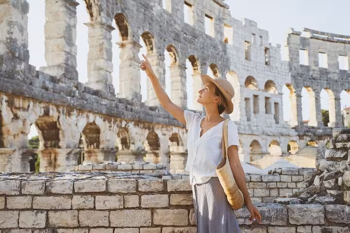 Traveler exploring the Colosseum arches in Rome on a self-guided tour with Palatine Hill and Forum access