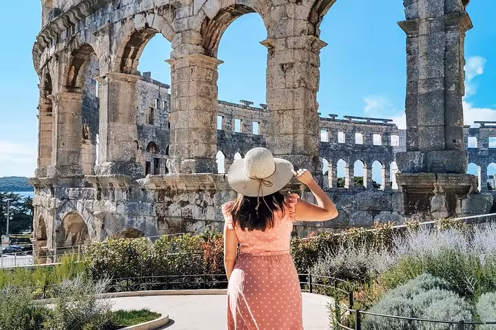 Visitor in sunhat admiring Rome’s Colosseum exterior on a self-guided adventure tour including Palatine Hill and Forum