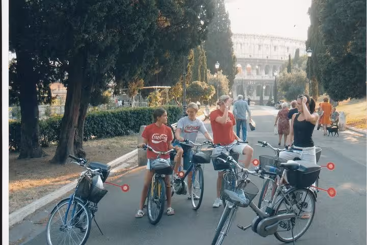 Tourists enjoy an e-bike adventure near the Colosseum in Rome, exploring iconic city highlights in a small group tour.