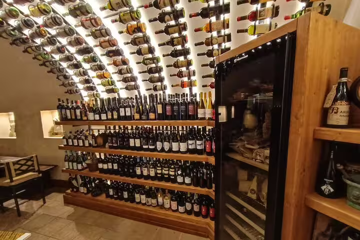 Curved wine cellar in Rome with shelves and ceiling lined with Italian bottles for Fabullus wine pairing experience