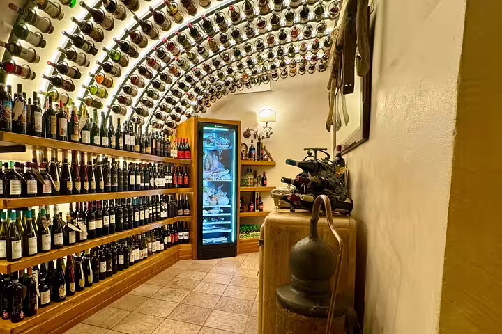 Elegant Roman wine cellar with arched bottle-lined ceiling and chilled meats display for Fabullus tasting menu tour