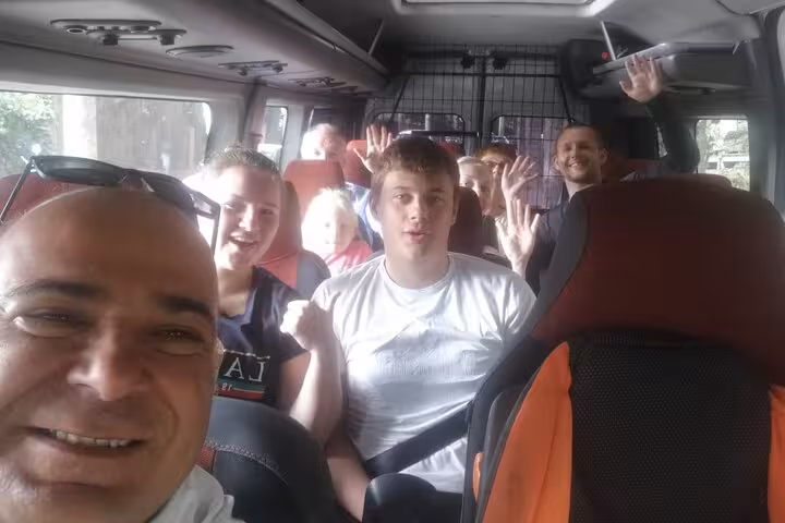 Happy group on minibus transfer from Rome to Florence for full-day sightseeing tour in Tuscany