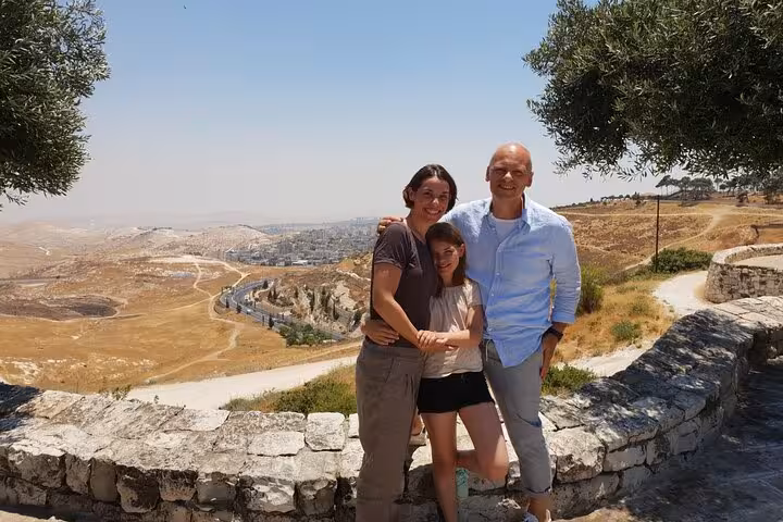 Family posing at scenic overlook on a Rome to Florence sightseeing day trip, enjoying Tuscan countryside views