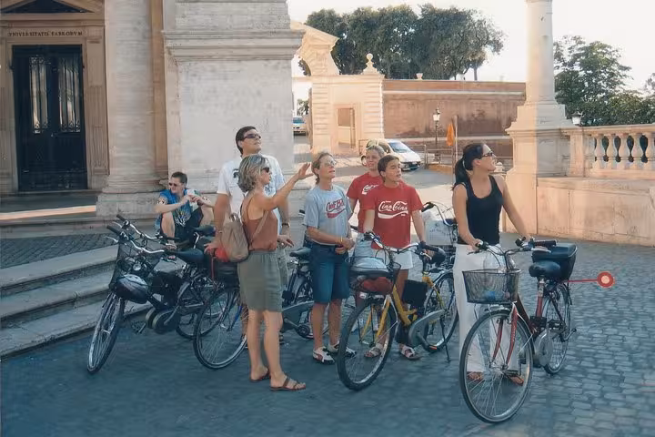A small group on e-bikes stops to admire architectural landmarks during a guided tour of Rome's historic sites.