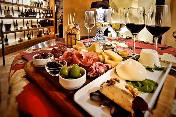 Gourmet Italian charcuterie board with cheeses, olives and red wine glasses on a Rome private food and wine tasting tour
