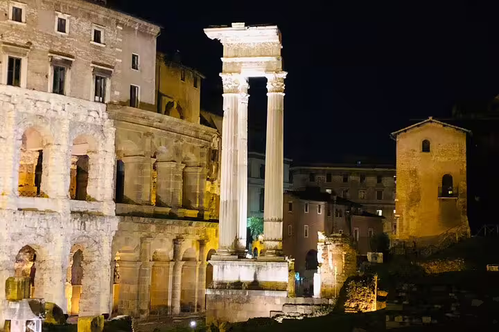 Ancient Roman Forum ruins and lit marble columns glowing at night on a private chauffeur-driven Rome sightseeing tour