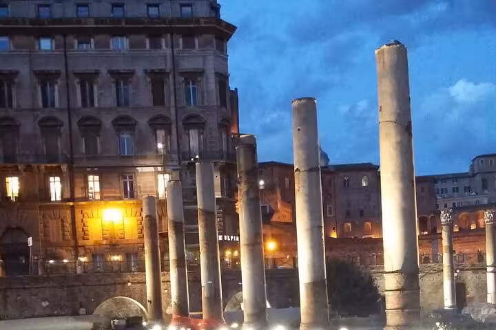 Majestic ancient columns in Rome's cityscape at dusk, perfect for a night Vespa tour adventure.