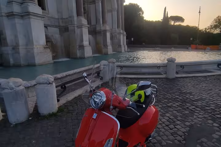 Experience Rome's stunning fountains on a Vespa, capturing the beauty of the Eternal City at dusk.