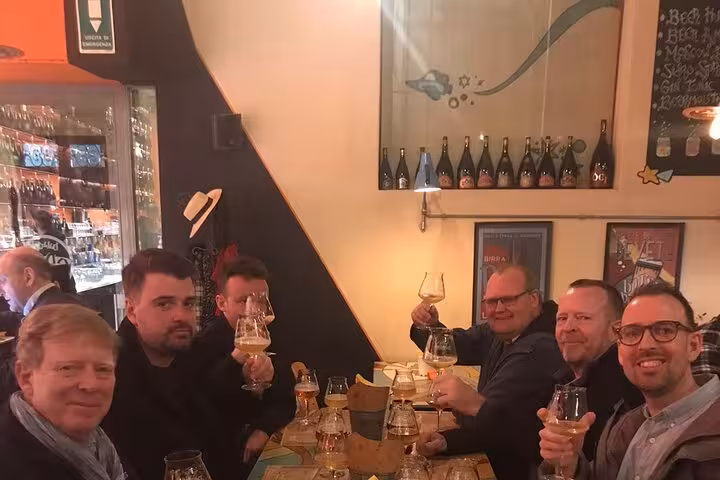 Group enjoying craft beer tasting at a cozy bar in Rome's Pigneto district during a private tour.